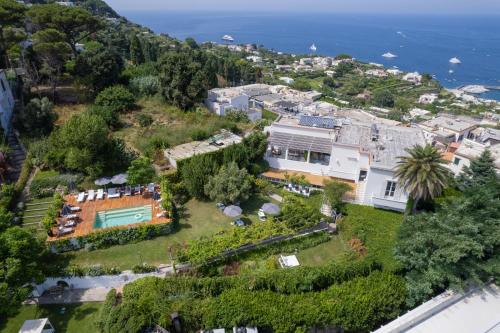 uma vista aérea de uma casa numa colina junto ao oceano em Villa La Pergola Capri em Capri