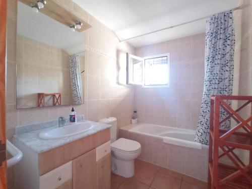 a bathroom with a toilet and a tub and a sink at Sa Vinya Casa de Campo in Es Cubells