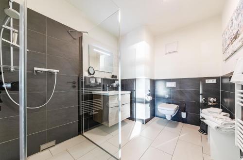 een badkamer met een douche, een toilet en een wastafel bij Hafenresidenz Waren (Müritz) in Waren