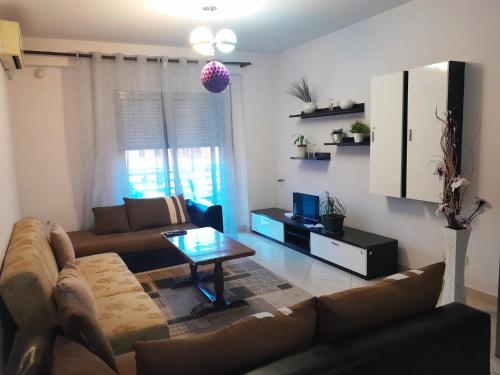 a living room with a couch and a table at ALPHA CITY CENTER APARTMENT in Shkodër