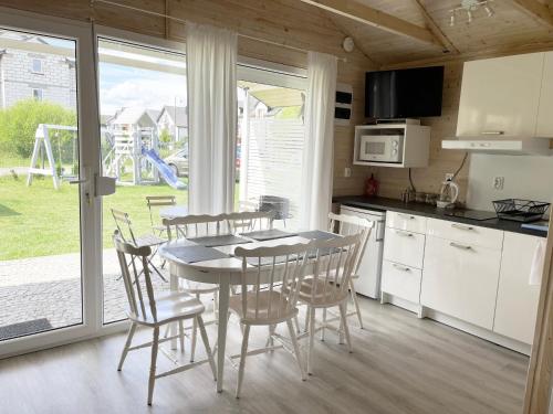 een keuken en eetkamer met een tafel en stoelen bij Domki Laba in Łeba