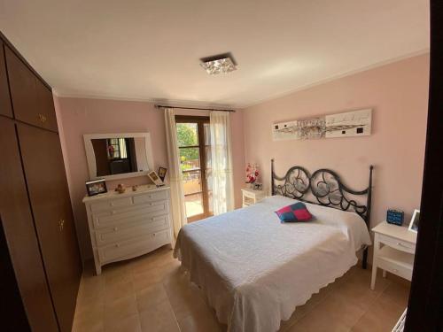 a bedroom with a bed and a dresser and a mirror at Casa con jardín en Roda de Bará in Roda de Bará