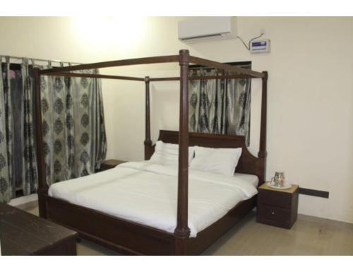 sypialnia z łóżkiem z drewnianą ramą w obiekcie AR Resort & Restaurant, Gauchar w mieście Chutwāpīpal