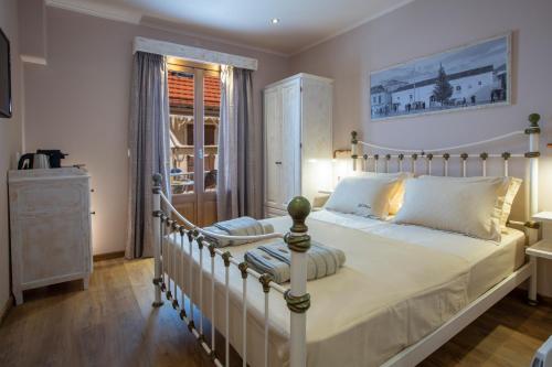 a bedroom with a large white bed and a window at BELLA VITA boutique hotel lefkada in Lefkada Town