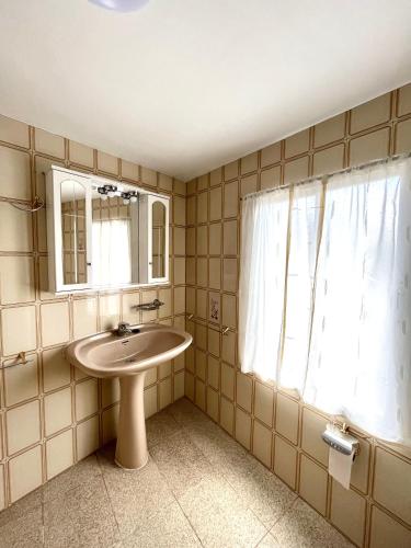 a bathroom with a sink and a mirror and a window at Casa Marina in Cerdido