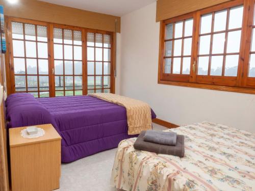 - une chambre avec 2 lits, une table et des fenêtres dans l'établissement Casa Manolo Camiño Do Santiaguiño, à Vedra
