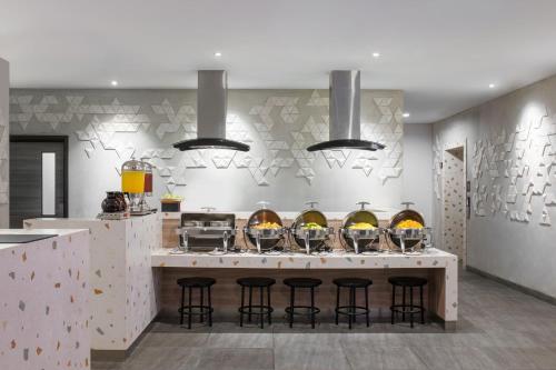a kitchen with a counter with bar stools at Amaris Hotel Kalimalang in Jakarta