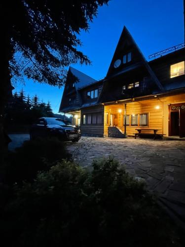 a house with a car parked in front of it at Apartament Władek in Biały Dunajec