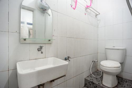 RedDoorz Syariah near PGC Cililitan في جاكرتا: حمام مع حوض ومرحاض ومرآة