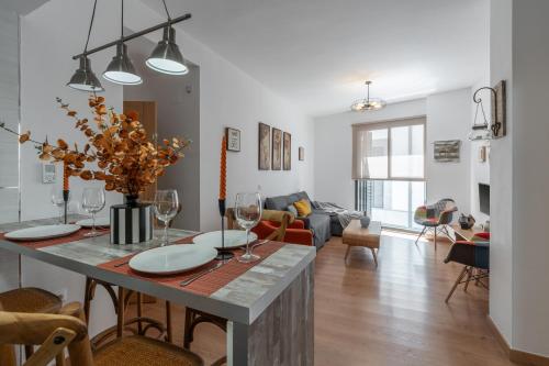 een keuken en een woonkamer met een tafel met wijnglazen bij tuGuest Postigo I Catedral Apartment in Granada