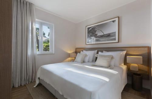 una camera da letto con un grande letto bianco e una finestra di Villa Berulia a Brela