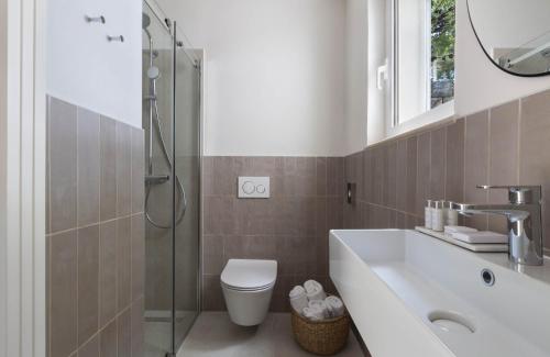 a bathroom with a toilet and a sink and a shower at Villa Berulia in Brela