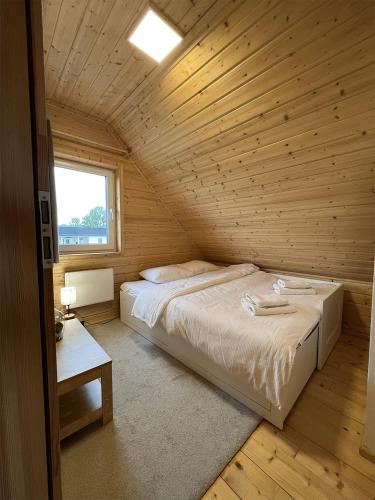 a bedroom with a bed in a wooden cabin at Domki z jacuzzi Dolny Śląsk noclegi premium Osada Aurora in Miszkowice