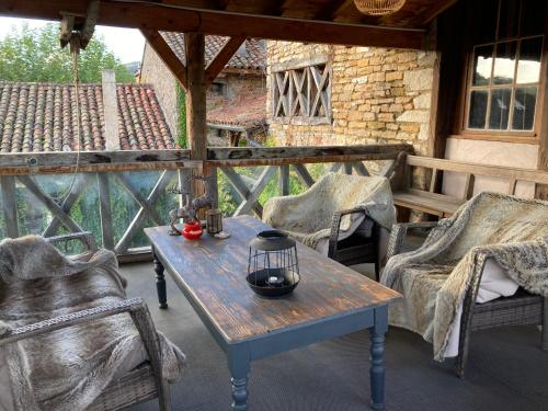 a wooden table and chairs on a patio at Art'Hotel & SPA Le Potin Gourmand in Cluny
