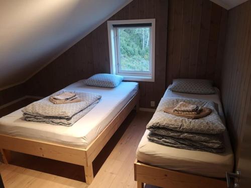 two twin beds in a room with a window at Stor og moderne hytte med panoramautsikt in Liagardane