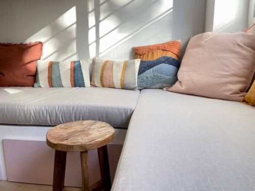 a white couch with pillows and a wooden stool at Casa Xava Valencia in Valencia