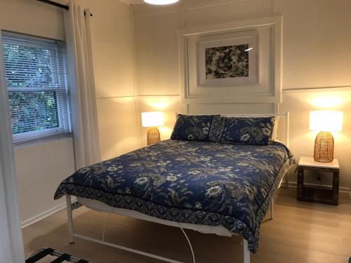 a bedroom with a bed and two lamps and a window at Sinclair Cottage in Port Lincoln