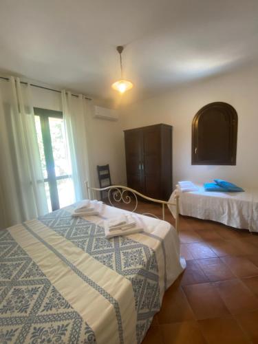サン・テオドーロにあるCase Vacanze Villa Rositaのベッドルーム1室(ベッド2台、窓付)
