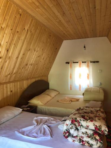 two beds in a room with a window at Guest House Ledio in Valbonë