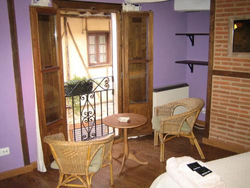 Cette chambre dispose d'un balcon avec une table et des chaises. dans l'établissement La Serranilla, à San Esteban de la Sierra