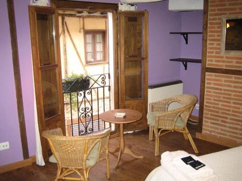 a room with a balcony with a table and chairs at La Serranilla in San Esteban de la Sierra