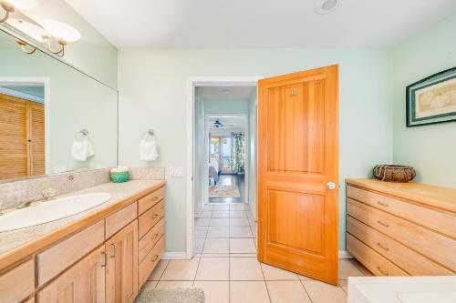 a bathroom with a sink and a wooden door at The Lilikoi - Entire home in Kailua-Kona