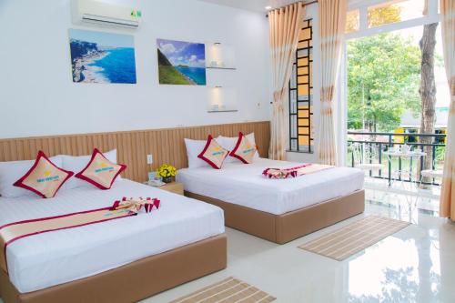 2 bedden in een kamer met een balkon bij Minh Minh Nam 2 Hotel in Can Tho
