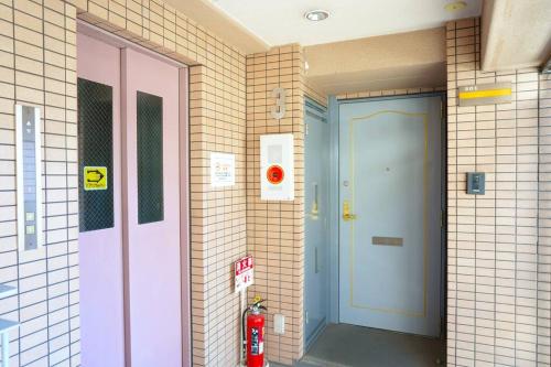 大阪B301/大阪人气景点黑门市场步行6分钟，日本桥、难波、心斋桥、道顿堀步行可达的一间设有灭火器的房间的粉红色和蓝色门