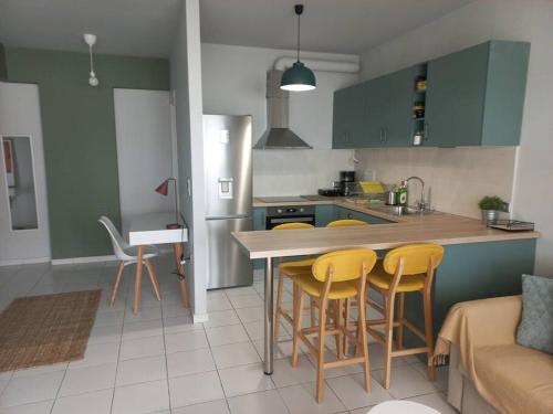 a kitchen with a table and yellow chairs in it at Centrally located apartment 2 in Volos