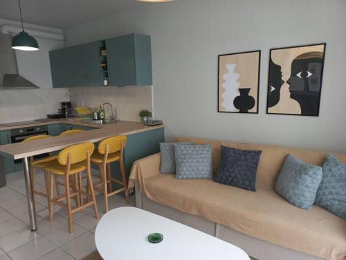 a kitchen and a living room with a couch and a table at Centrally located apartment 2 in Volos