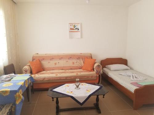 ein Wohnzimmer mit einem Sofa und einem Tisch in der Unterkunft Keno's Apartment in Sarandë