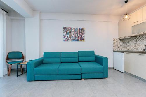 a living room with a blue couch and a table at FAOS Properties in Kavala