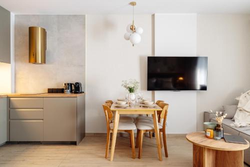 a kitchen and dining room with a table and chairs at Muse - LoftAffair Spa Collection in Kraków