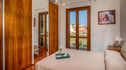 Zimmer mit einem Bett, einem Tisch und einem Fenster in der Unterkunft Villa delle Sirene 6, Emma Villas in Valderice