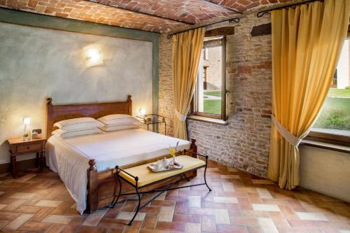 a bedroom with a bed and a table and a window at Relais Montemarino in Borgomale