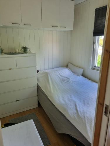 een kleine slaapkamer met een bed en een dressoir bij Trondheim/Nardo in Trondheim