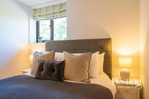 a bedroom with a bed with pillows and a window at Walkers Hideaway In The Heart Of The Chilterns With Incredible Views in Henley on Thames