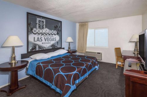 a hotel room with a bed and a desk at Super 8 by Wyndham Las Vegas North Strip/Fremont St. Area in Las Vegas