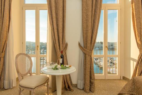 a room with a table and a window with a bottle of wine at San Paolo Al Convento in Trani