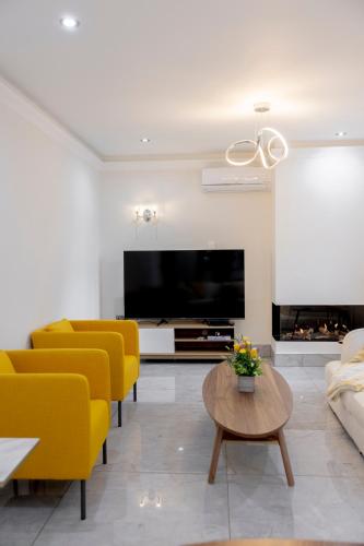 a living room with yellow chairs and a large television at New fully furnished 5 bedroom, 4 bathroom detached houses in Leicester