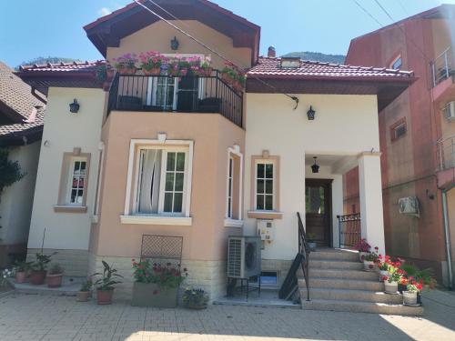a house with stairs and flowers in front of it at VILA ANA in Băile Herculane