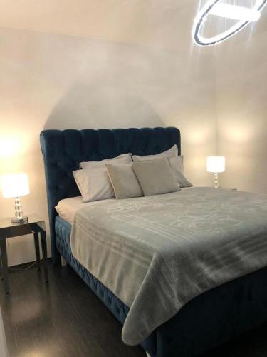 a bed with a blue headboard in a bedroom at Villa Ramljak in Mostar