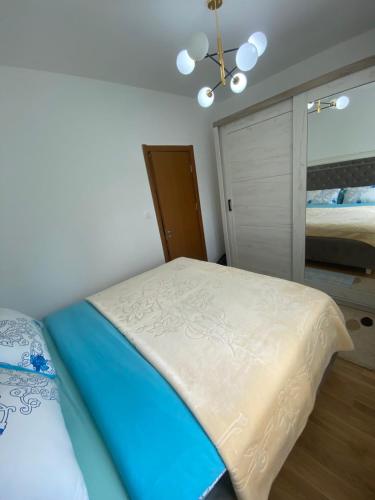a bedroom with a bed and a chandelier at Pirlitor Mountain Apartment in Žabljak