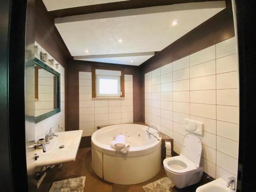 een badkamer met een bad, een toilet en een wastafel bij Villa Ramljak in Mostar