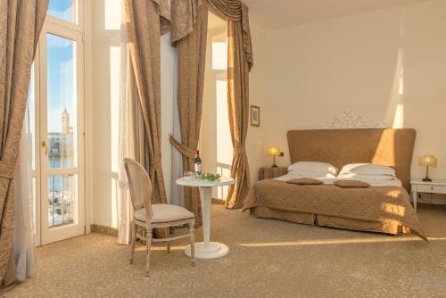 a bedroom with a bed and a table with a chair at San Paolo Al Convento in Trani
