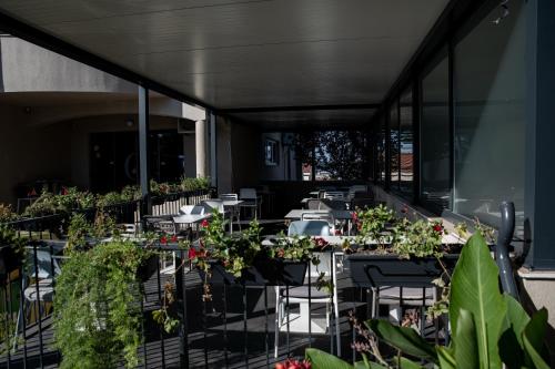 a balcony with tables and chairs with plants at Bellevue Hill apartment in Zadar