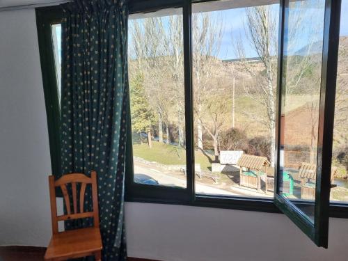 a window with a chair and a view of a park at NcantadaROOMS in Tragacete