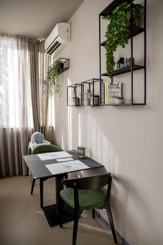 a dining room with a table and green chairs at Bellevue Hill apartment in Zadar