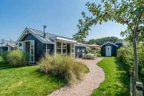 ein Haus mit einem Garten und einem Haus in der Unterkunft Duinpark Westerschouwen in Burgh Haamstede
