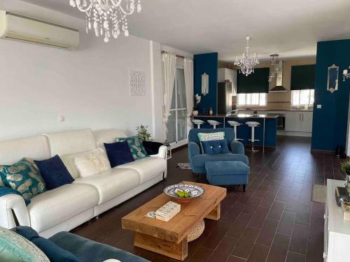 sala de estar con sofá blanco y sillas azules en Casa Pap, en Arboleas